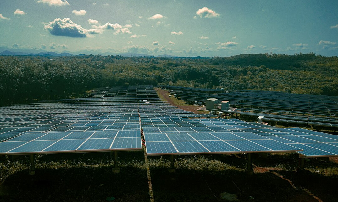 Solar panels in a field under blue sky